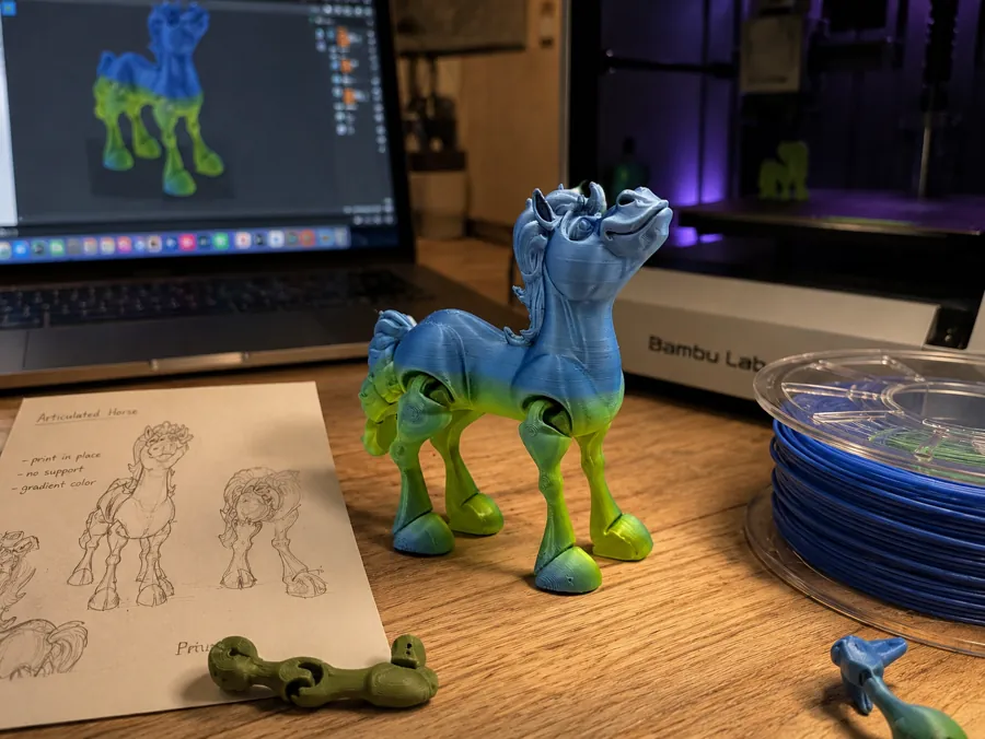 Mesa de trabajo con el proceso completo: el boceto a mano del caballo articulado con sus notas, el modelo 3D en la pantalla de la laptop, la pieza impresa en degradado azul a verde y la impresora al fondo